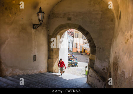 Blick auf einen Mann in eine typische mittelalterliche Arcade in der historischen Altstadt Hradcany Bezirk von Prag, tschechische Republik. Stockfoto