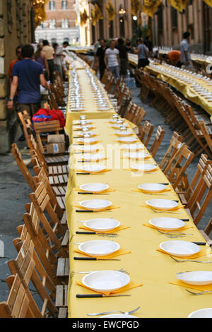 Siena gliedert sich in 17 Bezirke, bekannt als Contrade, und kämpfen sie, zehn von den Bezirken zu einer Zeit, in der zweimal ein Jahr, am 2. Juli und 16. August Pferderennen um den zentralen Platz Campo. Hier Einrichten eines langen Tischen für eines der Viertel der Nacht vor dem Palio-Pferderennen. Siena, Toskana. Italien. Juli. Stockfoto