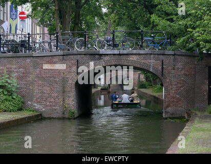 Personen auf einem Schiff unter einer Brücke am Nieuwegracht Kanal in der mittelalterlichen Innenstadt von Utrecht, Niederlande Stockfoto