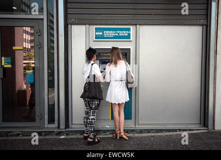 Zwei Frauen Bargeld von einem Geldautomaten (ATM) in Athen am 23. Juni 2015. Foto: Sokrates Baltagiannis/dpa Stockfoto