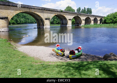 Zwei Kajaks geladen mit Campingausrüstung am Ufer des Flusses Dordogne, in der Nähe der Brücke bei Castelnaud la Chapelle, Frankreich Stockfoto