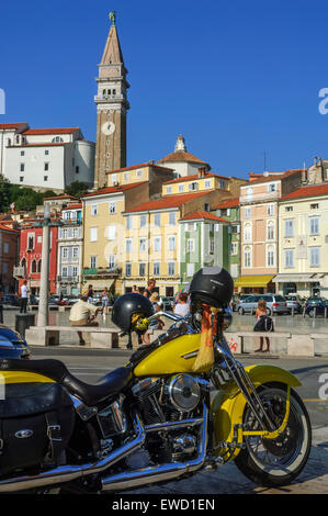 Eine gelbe Harley Davidson Motorrad in Tartini-platz geparkt mit St. George's Kirche hinter sich. Piran. Slowenien Stockfoto