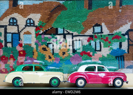 Zwei Dinky-Modellautos in leuchtenden Farben vor farbenfrohem Hintergrund Stockfoto