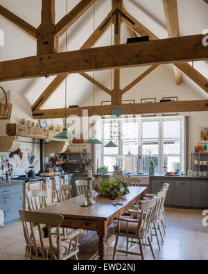 Vintage Bauernhof-Tisch im rustikalen Küche mit grünen Pendelleuchten von Holloways Ludlow, Aga und Balkendecke Stockfoto