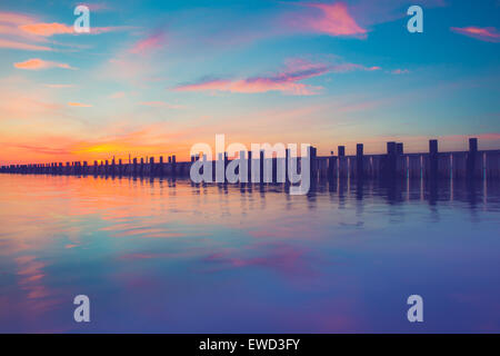 Schönen Meer Szene mit hölzernen Pier bei Sonnenuntergang Stockfoto