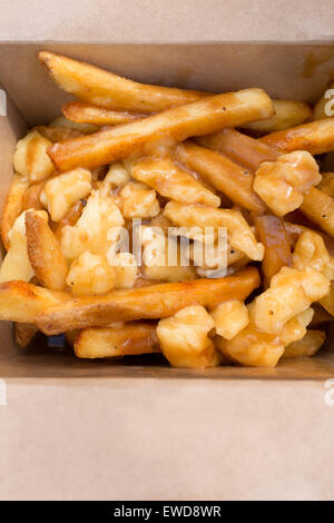 Poutine – eine kanadische Delikatesse aus Pommes frites oder Pommes Frites mit Soße und Käsequark, die auf dem Brick Lane Market in London angeboten wird Stockfoto