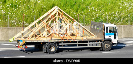 Lkw LKW-Ladung werkseitig vormontiert Holz vorgefertigten Dachstühlen Bau Materialien auf einem Tieflader fahren auf Autobahn England Großbritannien Stockfoto