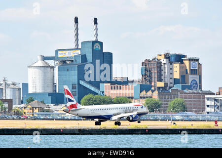 British Airways Flug Landung am Flughafen London City mit Tate und Lyle Silvertown Zuckerfabrik Fabrikgebäude über Newham London Docklands GROSSBRITANNIEN Stockfoto