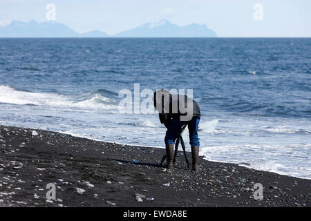 Fotografen, die Fotos von Eisbergen Abwasch am schwarzen Sandstrand am Jökulsárlón Island Stockfoto