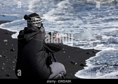 Fotografen, die Fotos von Eisbergen Abwasch am schwarzen Sandstrand am Jökulsárlón Island Stockfoto