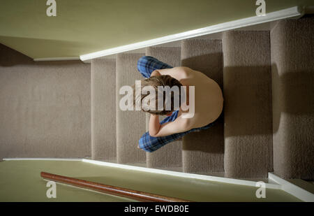 Ein Kind sitzt auf der Treppe mit dem Kopf in seine Hände suchen verärgert