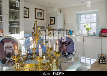 Esszimmerstühle gepolstert in Corys Visitorian Drucke um Glas Esstisch in der Küche mit weißen Kommode und Aga gekrönt Stockfoto