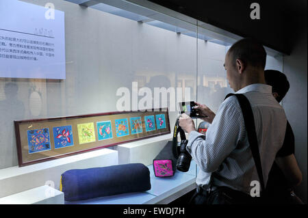 Changchun, China Jilin Provinz. 24. Juni 2015. Ein Besucher nimmt Fotos von Kunstwerken Man ethnische Gruppe während einer Mann-Stickerei-Ausstellung in Changchun, Hauptstadt des nordöstlichen Chinas Provinz Jilin, 24. Juni 2015. Bildnachweis: Zhang Nan/Xinhua/Alamy Live-Nachrichten Stockfoto