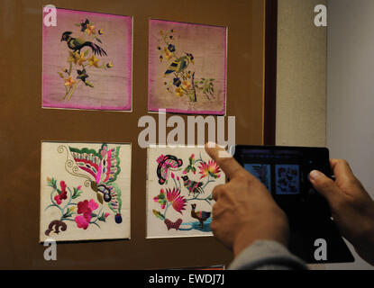 Changchun, China Jilin Provinz. 24. Juni 2015. Ein Besucher nimmt Fotos von Kunstwerken Man ethnische Gruppe während einer Mann-Stickerei-Ausstellung in Changchun, Hauptstadt des nordöstlichen Chinas Provinz Jilin, 24. Juni 2015. Bildnachweis: Zhang Nan/Xinhua/Alamy Live-Nachrichten Stockfoto