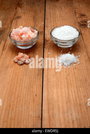 Rosa Himalayasalz und Meersalz auf einem Holztisch Stockfoto