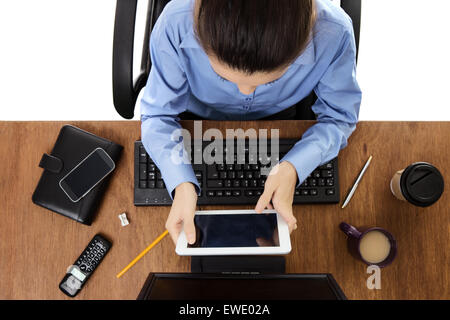 Frau arbeitet an Ihrem Schreibtisch mit einem Schuss aus der Vogelperspektive schaut tablet Stockfoto