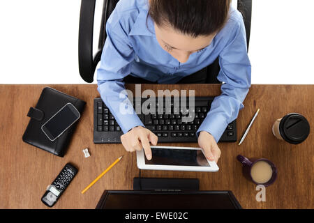 Frau arbeitet an Ihrem Schreibtisch mit einem Schuss aus der Vogelperspektive schaut tablet Stockfoto