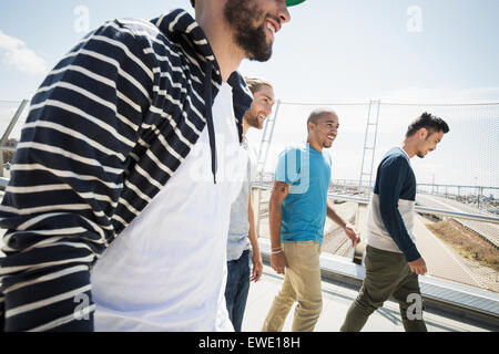 Gruppe junger Männer zu Fuß entlang der Fußgängerbrücke Stockfoto