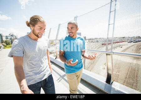 Zwei junge Männer zu Fuß entlang der Fußgängerbrücke Stockfoto