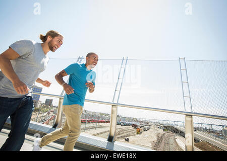 Zwei junge Männer, die Fußgängerbrücke Joggen Stockfoto