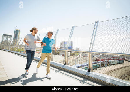 Zwei junge Männer, die Fußgängerbrücke Joggen Stockfoto