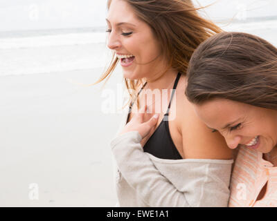 Nahaufnahme von zwei lächelnde junge Frauen zu Fuß am Strand Stockfoto
