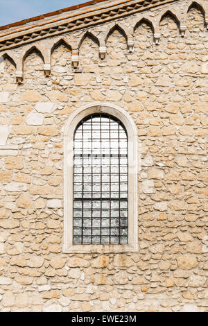 Gewölbte Fenster in der alten mittelalterlichen Steinwand Stockfoto