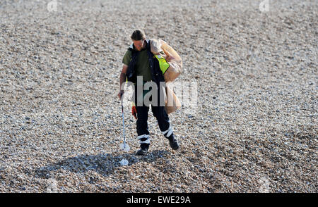 Ein Brighton und Hove City Council Arbeiter aufräumen Wurf auf Brighton Beach am frühen Morgen Stockfoto