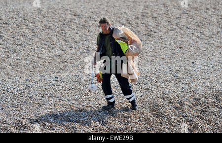 Ein Brighton und Hove City Council Arbeiter aufräumen Wurf auf Brighton Beach am frühen Morgen Stockfoto