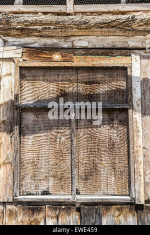 Alte Holzfenster, bedeckt mit einem Metallgitter in Spanien Stockfoto