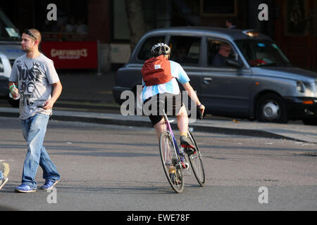 Ein Radfahrer, Fußgänger beim Überqueren einer Straße in London herumfahren Stockfoto