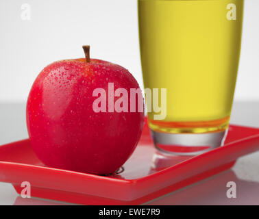 Rote Äpfel und Apfelsaft auf rotem Schild. Stockfoto