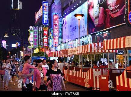 Nacht-Ansicht von Nanjing East Road (Leuchtreklamen leuchtet auf) die Straße ist die Haupteinkaufsstraße der Stadt. Shanghai China Chinesisch (Besucher an der Nanjing Road. Die Haupteinkaufsstraße von Shanghai. (Eine der belebtesten Einkaufsstraßen der Welt) (abends Nacht Neonlicht Billboard) Stockfoto