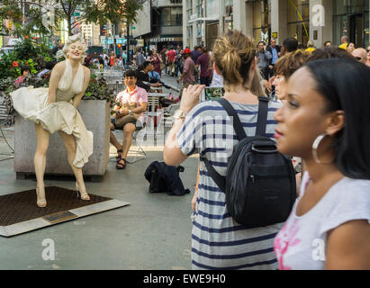 Passant interagieren mit Forever Marilyn vom Künstler Seward Johnson auf dem Broadway Fußgängerzone Plätze im Garment District in New York auf Montag, 22. Juni 2015. Achtzehn Jahren gemalt lebensgroße Bronze-Skulpturen von Johnson Gnade die Plazas, einige der berühmten Fotos und andere alltägliche Menschen alltägliche Dinge zu tun. Die Ausstellung wird bis zum 15. September sein. (© Richard B. Levine) Stockfoto