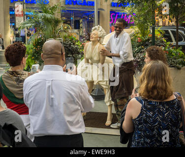 Passant interagieren mit Forever Marilyn vom Künstler Seward Johnson auf dem Broadway Fußgängerzone Plätze im Garment District in New York auf Montag, 22. Juni 2015. Achtzehn Jahren gemalt lebensgroße Bronze-Skulpturen von Johnson Gnade die Plazas, einige der berühmten Fotos und andere alltägliche Menschen alltägliche Dinge zu tun. Die Ausstellung wird bis zum 15. September sein. (© Richard B. Levine) Stockfoto