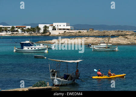 ELS Pujols Strand auf Formentera mit traditionellen Fischerboot und Kajaks im Sommertag. Llaüt Boote. Stockfoto