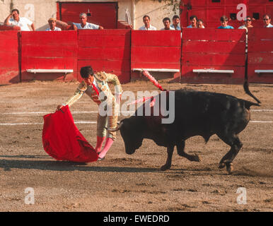 CARACAS, VENEZUELA - Matador Wellen roten Kap vor Laden Stier beim Stierkampf in der Arena. 1988 Stockfoto