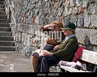 Zwei ältere Frauen sitzen auf einer Bank in der Sonne. Baskisches Land. Spanien. Stockfoto