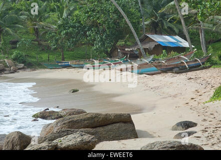 Strand mit schmalen Türkis leichte Holz Boote und alten Schuppen mit Wellblechdach am Rocky Point Strand am 19. Dezember, 20 Stockfoto