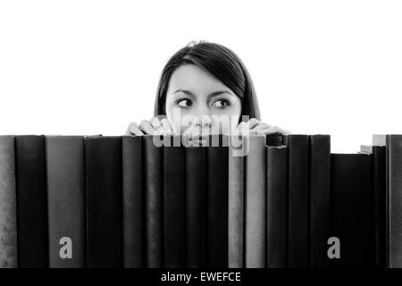 Frau auf der Suche über Bücher auf einem Regal Stockfoto