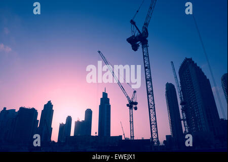 Sonnenuntergang Skyline von Baukränen unter Office Tower Wolkenkratzer im Nahen Osten Zentrum des Handels, Dubai Stockfoto