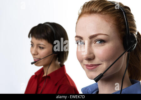 Zwei Business-Frau trägt Kopfhörer arbeiten hart, um Sie glücklich zu machen Stockfoto