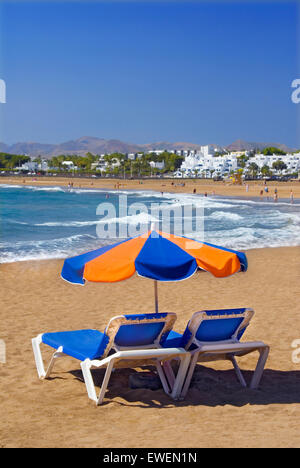 Playa del Carmen Strand Sonnenschirm zwei Sonnenliegen Küste sonnig goldenen Sandstrand mit Sonnenschutz urlaub Sonnenschirm, Lanzarote, Kanarische Inseln, Spanien Stockfoto