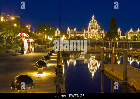 Victorias Inner Harbour in der Dämmerung mit einem Marktstand am Wasser und dem berühmten Wahrzeichen, der BC UNPA leuchtet Stockfoto