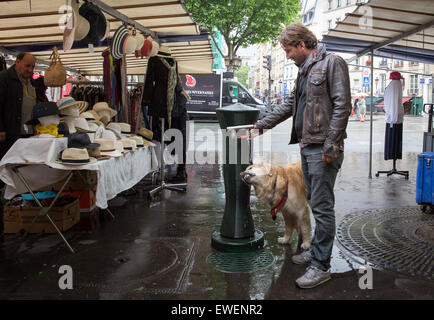 Hund immer einen Schluck Wasser aus einem öffentlichen Brunnen in Paris, Frankreich Stockfoto