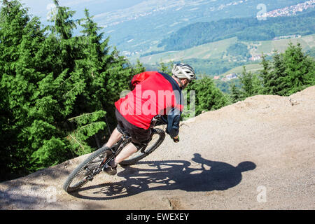 Mountain-Bike-Fahrer fährt durch Schwerkraft Hang eine künstliche Feldweg. Der Hintergrund zeigt der Schwarzwald in Deutschland. Stockfoto