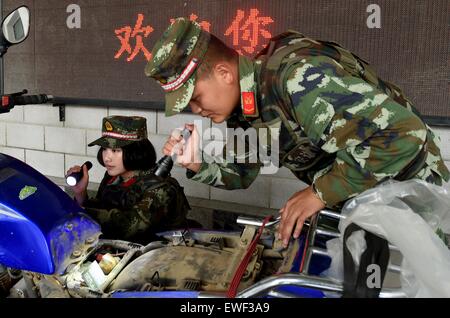 (150625)--DEHONG, 25. Juni 2015 (Xinhua)--Zhang Liu (L) und ihrer Kameraden überprüfen refitted Motorrad für Schmuggelware auf den Grenzübergang von Mukang in Dehong Dai-Jingpo autonomen Präfektur, der südwestlichen chinesischen Provinz Yunnan, 24. Juni 2015. Im Jahr 1995 geborene Zhang Liu eines Anti-Drogen-Soldaten im Grenzübergang von Mukang im Jahr 2013.  Aufgewachsen in einer wohlhabenden Familie in der Provinz Hunan Zentral-China, sagte Zhang, Soldat schon immer ihr Traum gewesen, sie fuhr in die Armee eintreten, nach Abschluss der High School. Eine Frontlinie Anti-Drogen Kraft, der Grenzübergang von Mukan Stockfoto