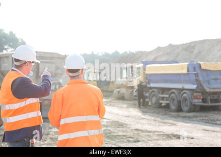 Vorgesetzten erklären Plan an Kollegen auf Baustelle Stockfoto