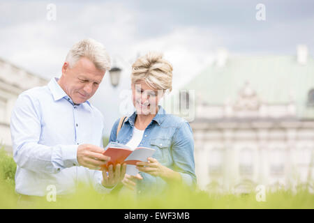 Lächelnde Paar mittleren Alters lesen Ratgeber im freien Stockfoto