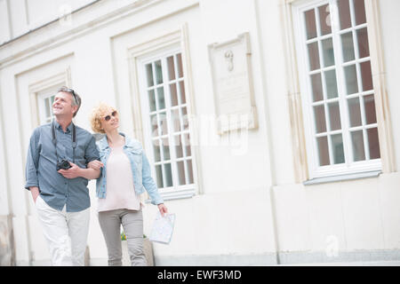 Glücklich im mittleren Alter Tourist paar gehen Arm in Arm durch den Bau Stockfoto